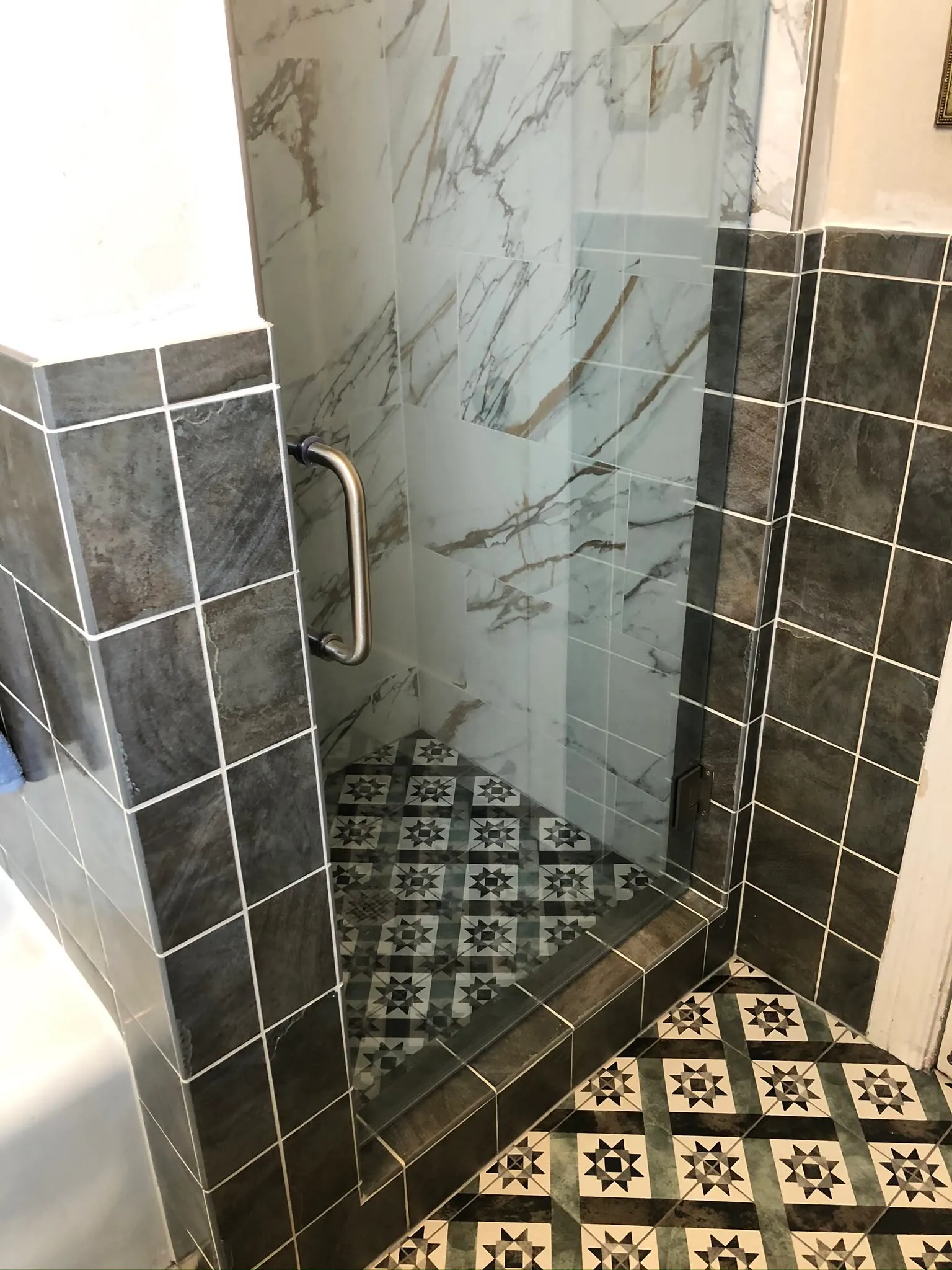 Shower with dark wall tile and cement tile floor in a Vallejo bathroom