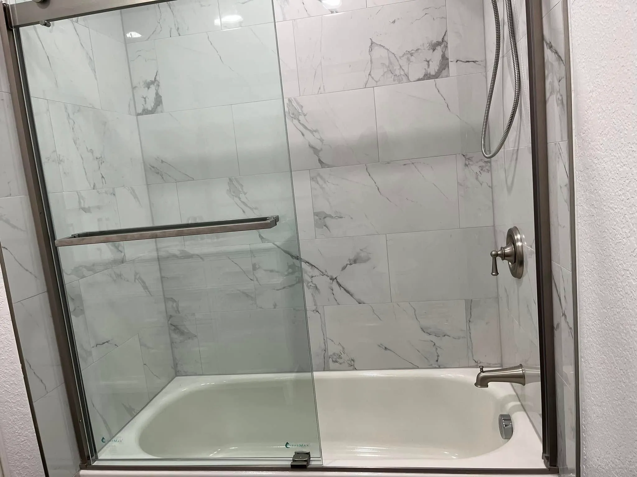 Glass shower door over marble-look tile in a Vallejo bathroom remodel