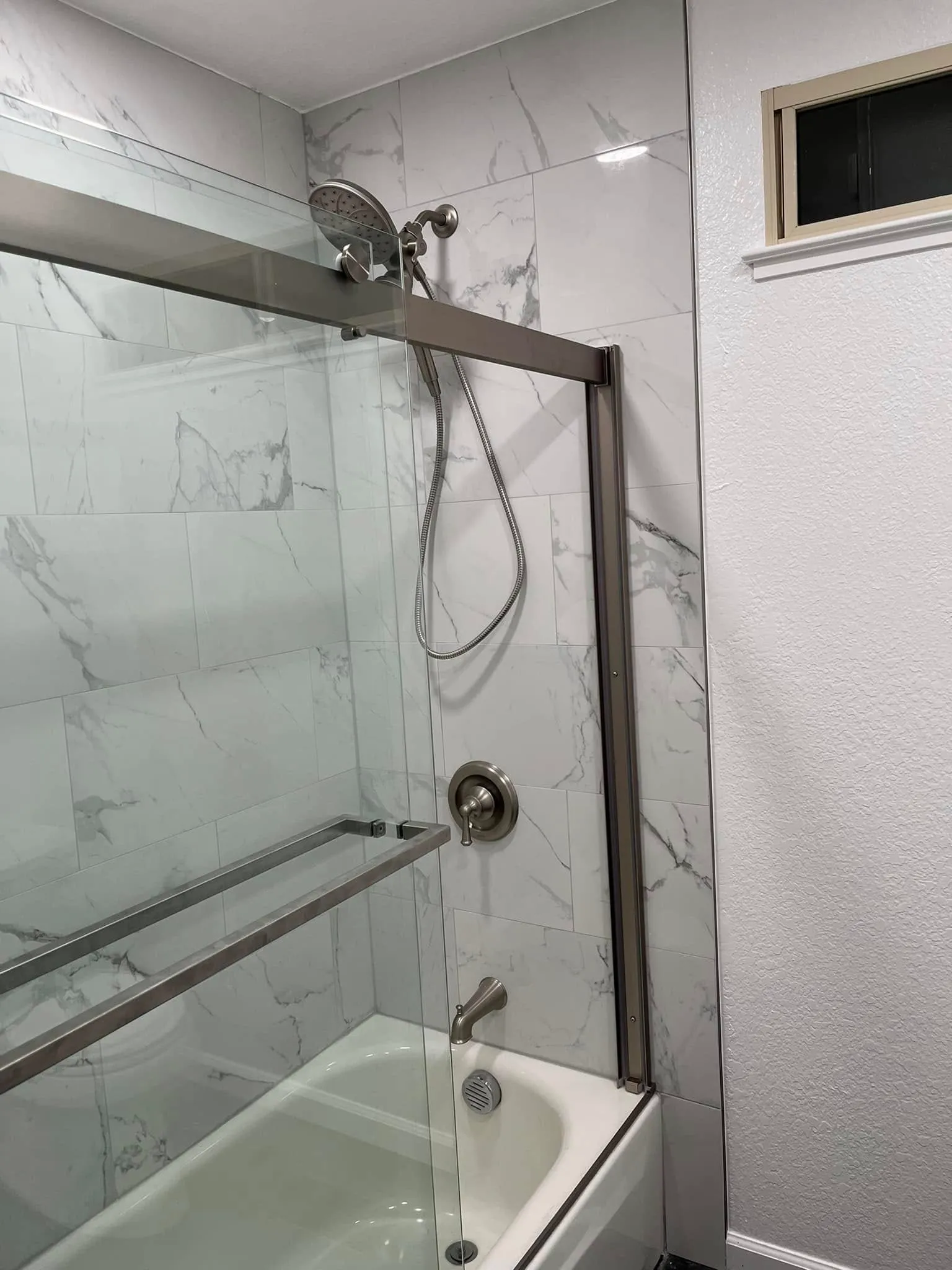 Marble-look shower tile with a sliding glass door in a Vallejo bathroom