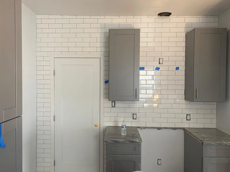Subway tile backsplash going up behind gray cabinets in a Vallejo kitchen