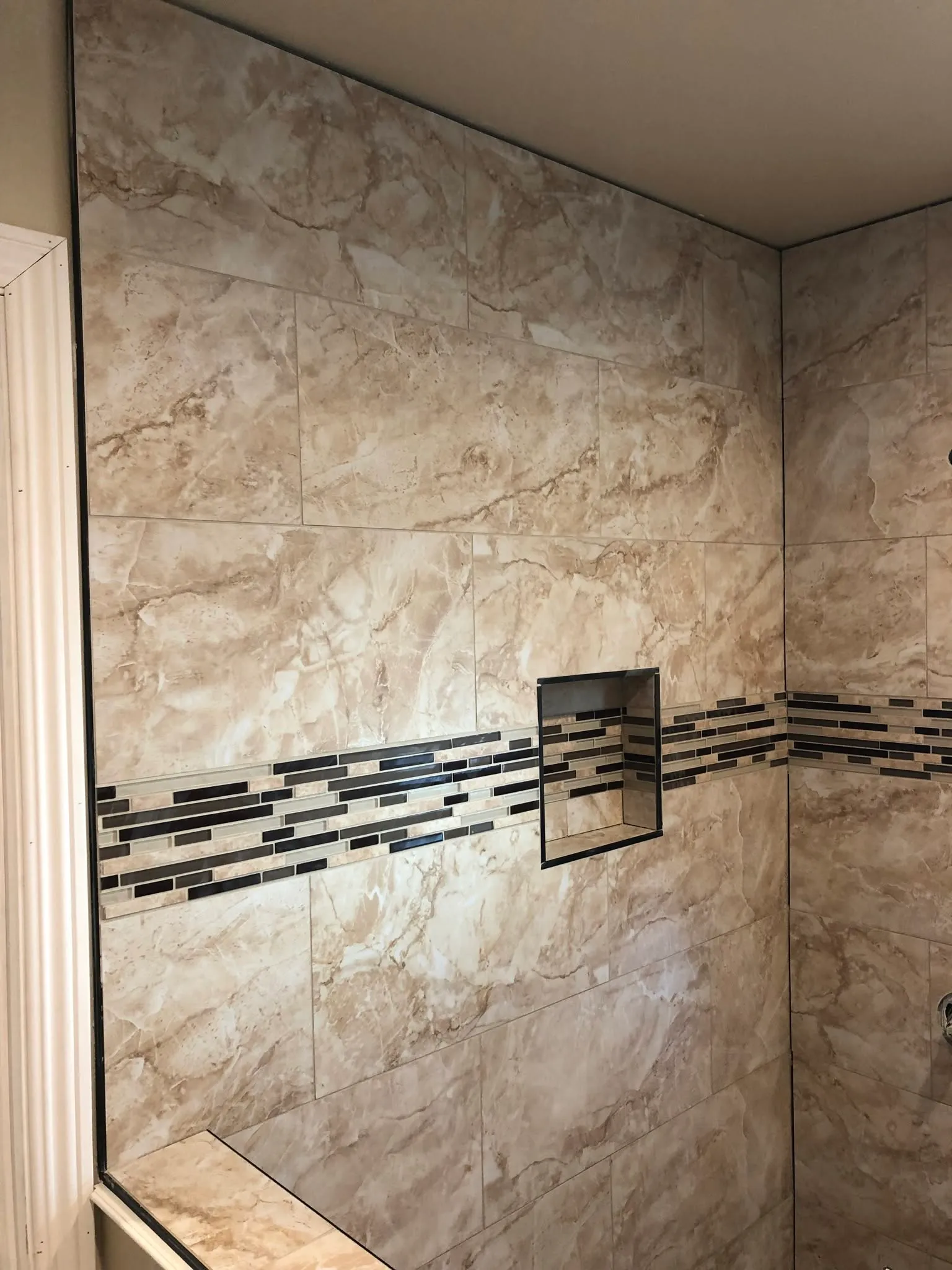 Shower wall tile with a mosaic accent band and recessed niche in Vallejo