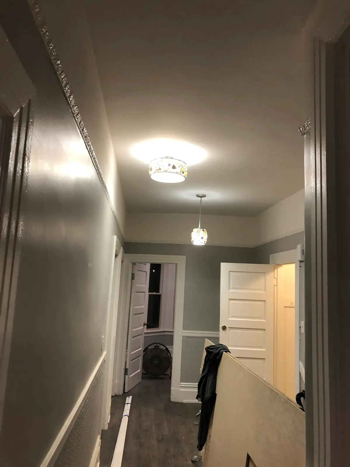Painter in Vallejo finishing gray walls and trim in a hallway